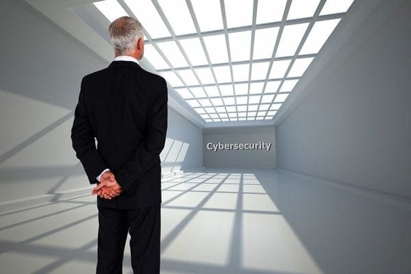 A professional in a suit stands in a modern, well-lit room with a grid ceiling, considering Independent Cyber Risk Diligence displayed ahead.